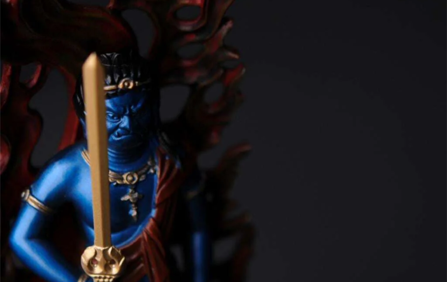 Close-up of a blue Fudo Myoo (Acala) statue holding a sword with a flaming halo