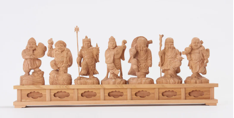 Set of seven wooden Shichifukujin (Seven Lucky Gods) statues displayed on a long base
