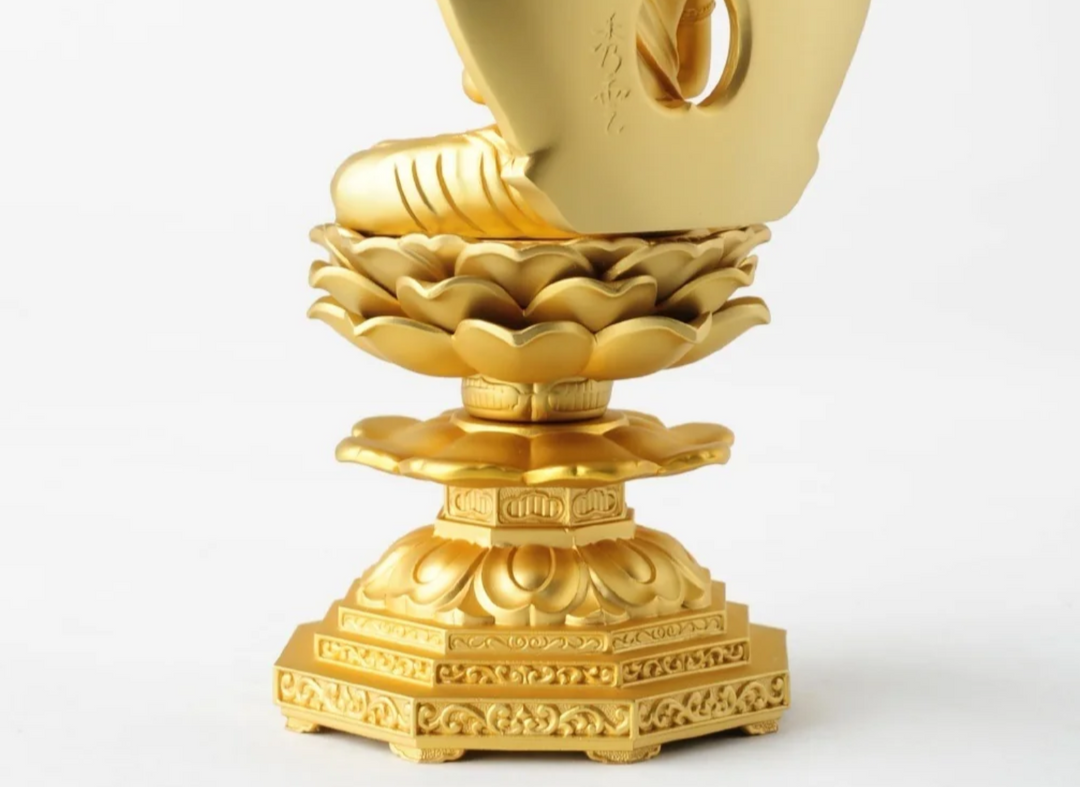 Close-up of a golden Buddhist statue seated on an ornate lotus pedestal, highlighting the layered base and decorative features used to identify Buddhist statues.