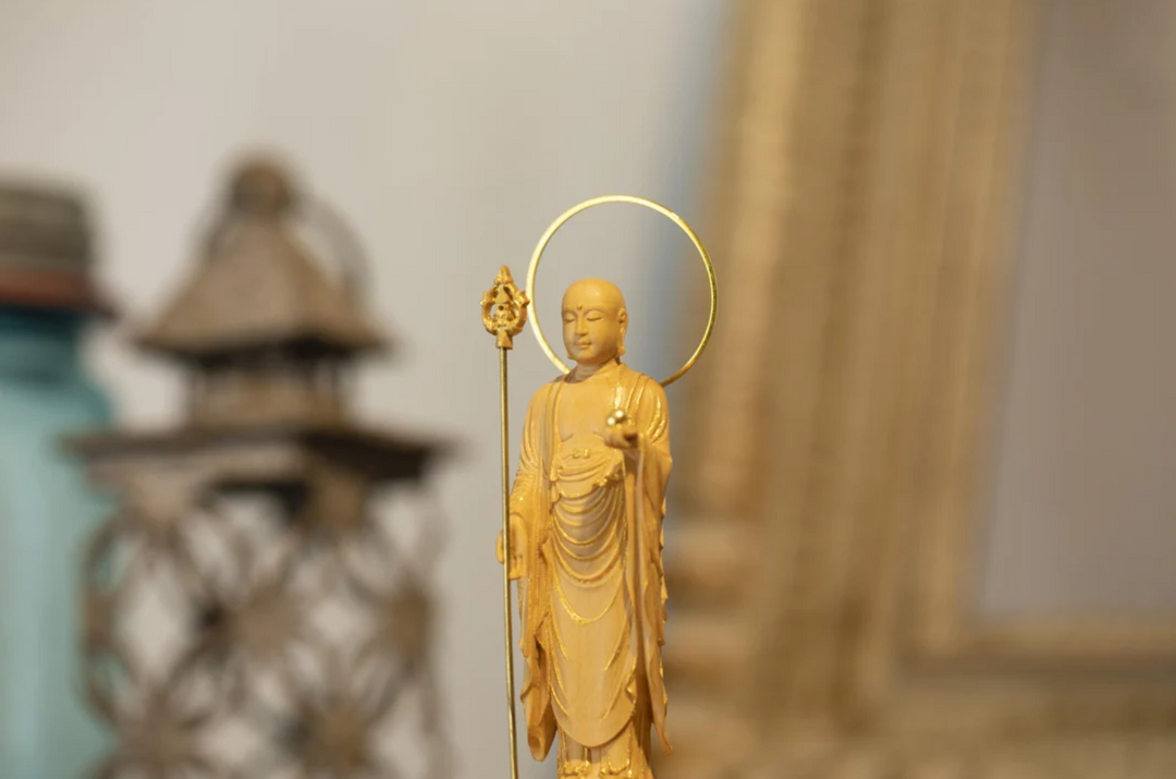Standing Jizo statue with a halo, staff, and wish-fulfilling jewel, representing compassion, protection, and the spiritual meaning of Jizo mantra practice.