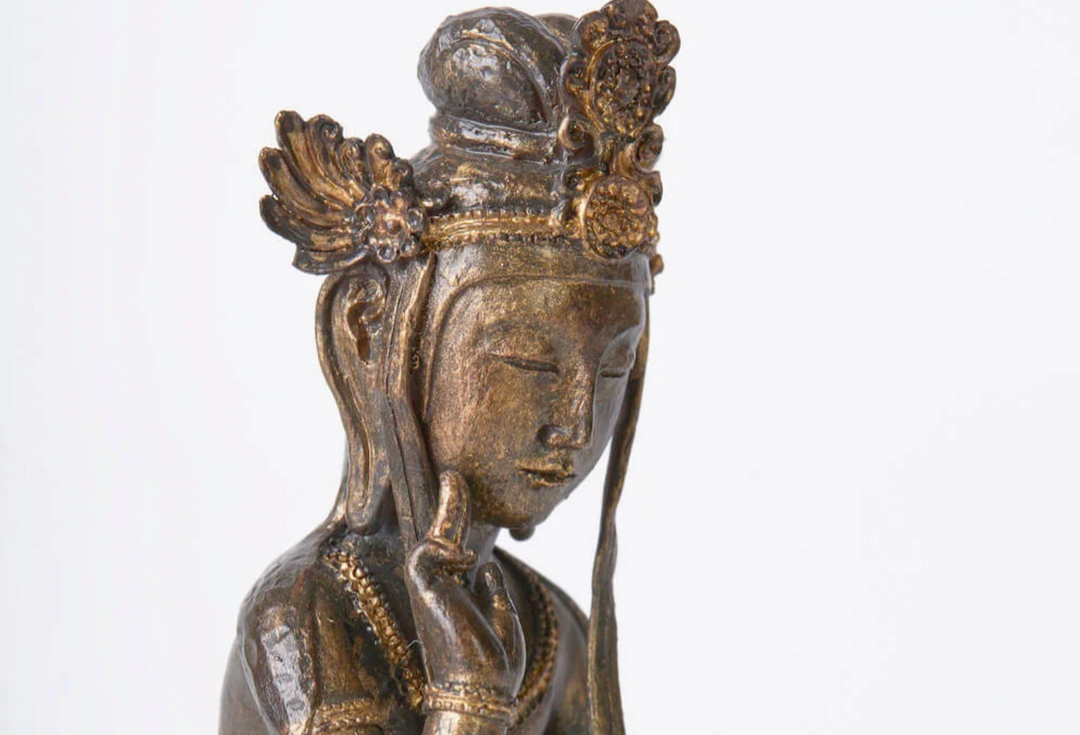 Close-up of a contemplative Maitreya statue with an ornate crown and serene expression, representing the future Buddha awaiting rebirth in Tusita Heaven.