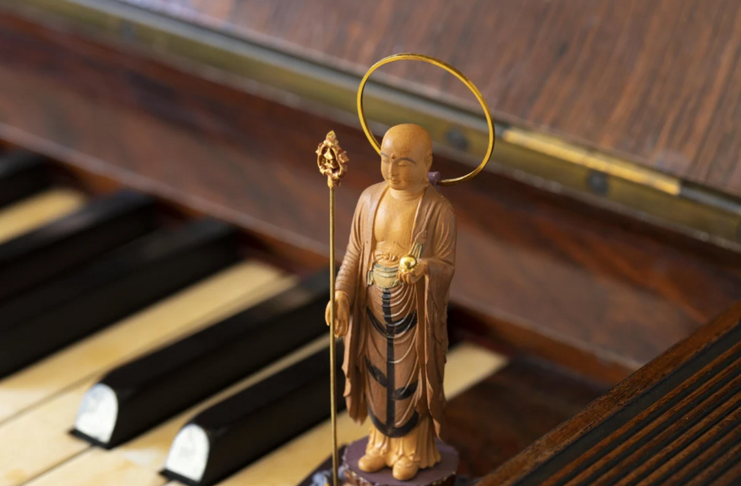 Standing Jizo statue with a halo, staff, and jewel, displayed indoors to illustrate respectful placement of a Jizo statue at home.