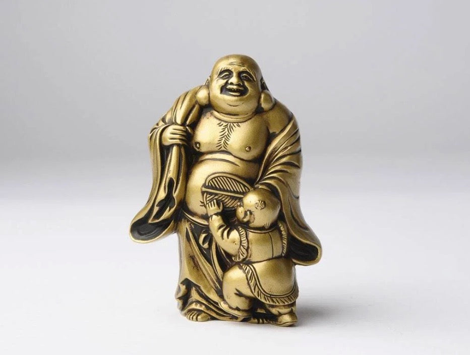 Golden Budai statue depicting the Laughing Buddha monk standing with a small child.
