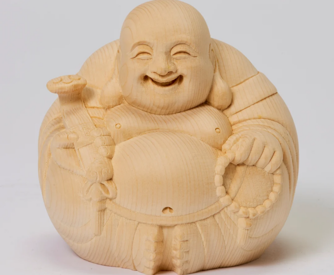 Wooden Laughing Buddha statue with a smiling face, round belly, prayer beads, and a staff, illustrating the Chinese image of Budai associated with Maitreya.