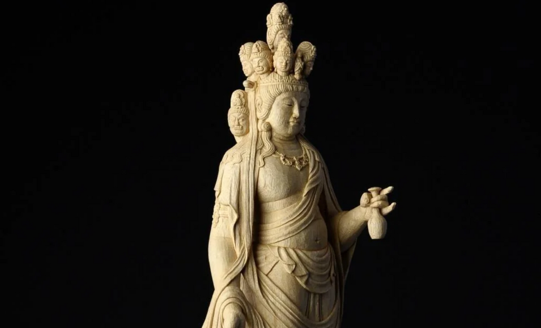 Close-up of a serene Guanyin statue holding a small vase, symbolizing compassion, purification, and the nourishing grace associated with this bodhisattva.