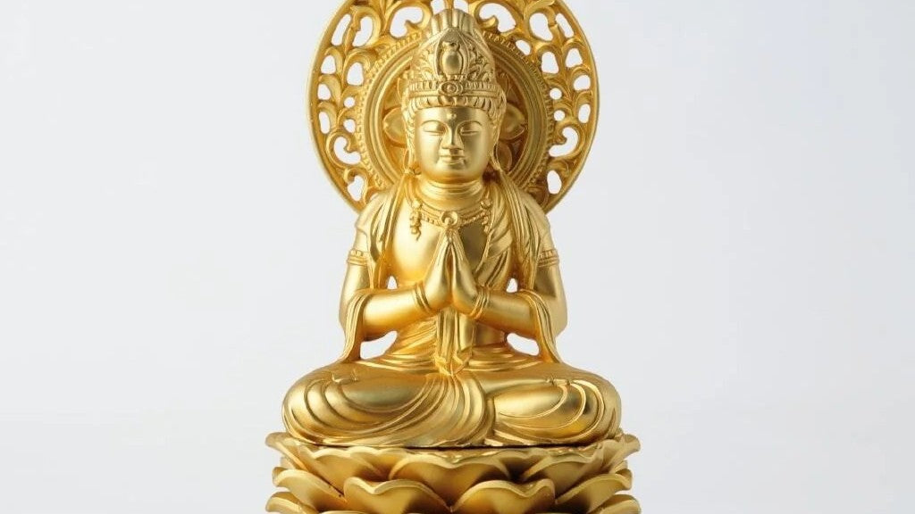 Golden Amida (Amitabha) Buddha statue seated on a lotus pedestal with hands in prayer (gassho), with an ornate halo