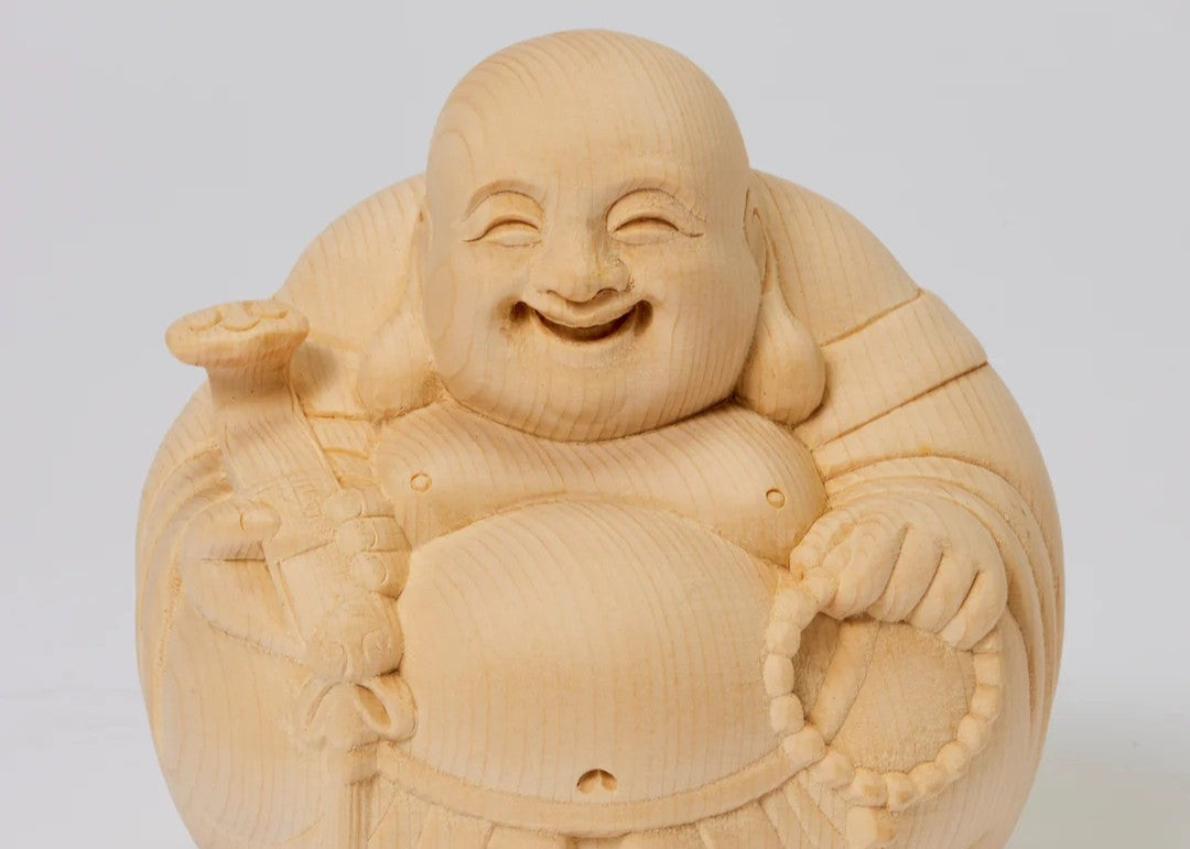 Wooden Hotei (Laughing Buddha) statue smiling and holding prayer beads and a sack