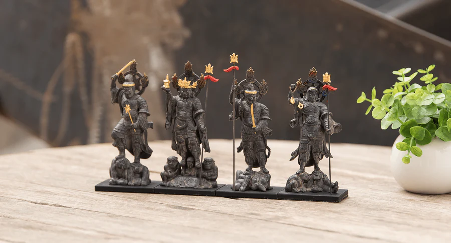 Set of four wooden Shitenno (Four Heavenly Kings) statues standing on bases, displayed on a table