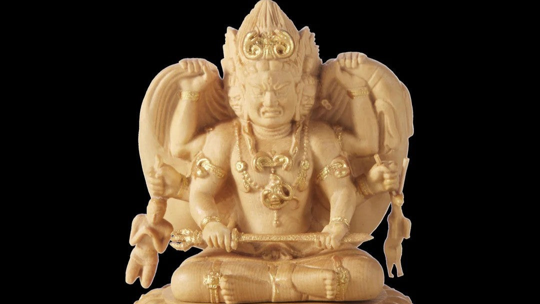 Wooden Ashura (Asura) statue with multiple arms and fierce expression, seated and holding weapons